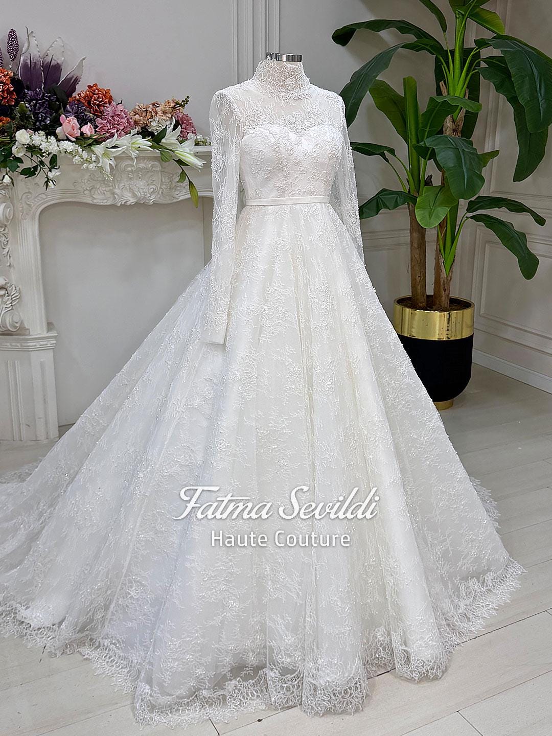 Elegant white lace wedding gown with high neck, long sleeves, floral embroidery, corset back, beads and veil