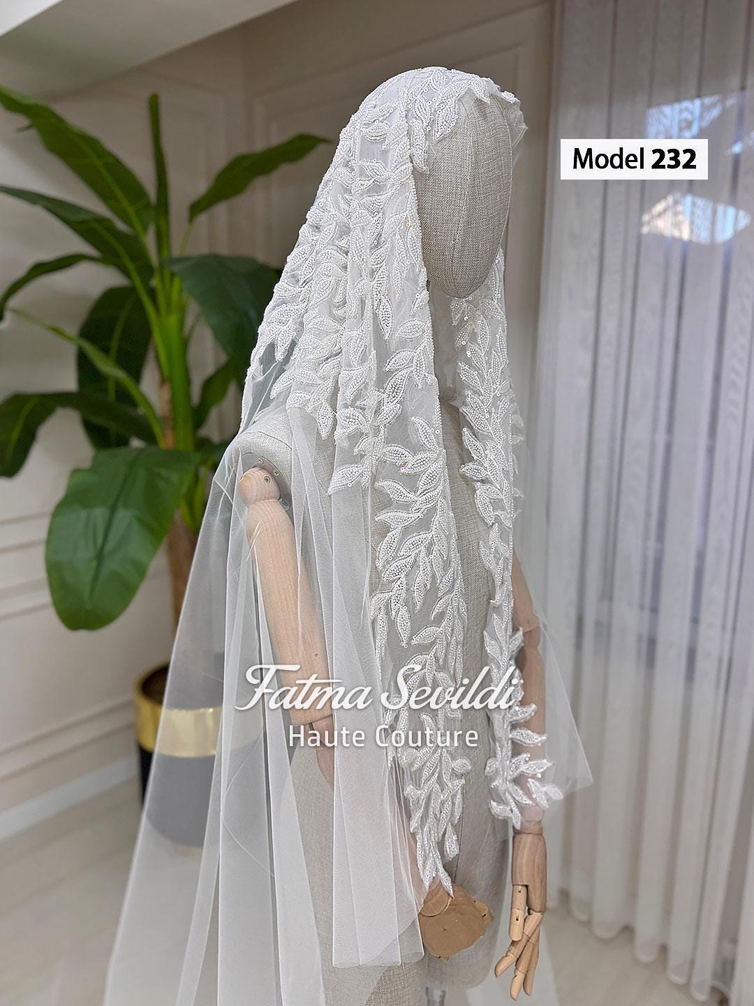 Elegant white lace veil with leaf embroidery on mannequin