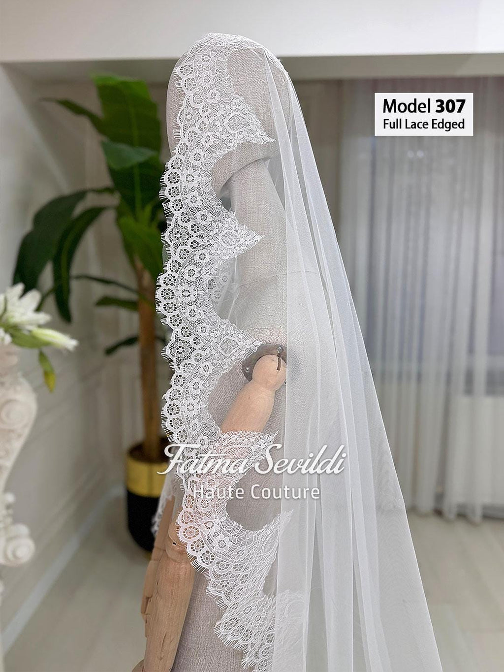 White sheer cathedral veil with lace edging on mannequin
