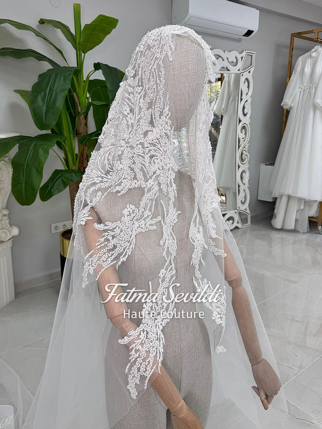 Delicate white lace veil with floral embroidery on bridal mannequin