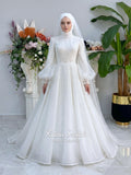 Luxury hijab wedding dress in an A-line tulle ball gown silhouette with long balloon sleeves, high neck, sparkling beadwork, and a lace-edged veil.