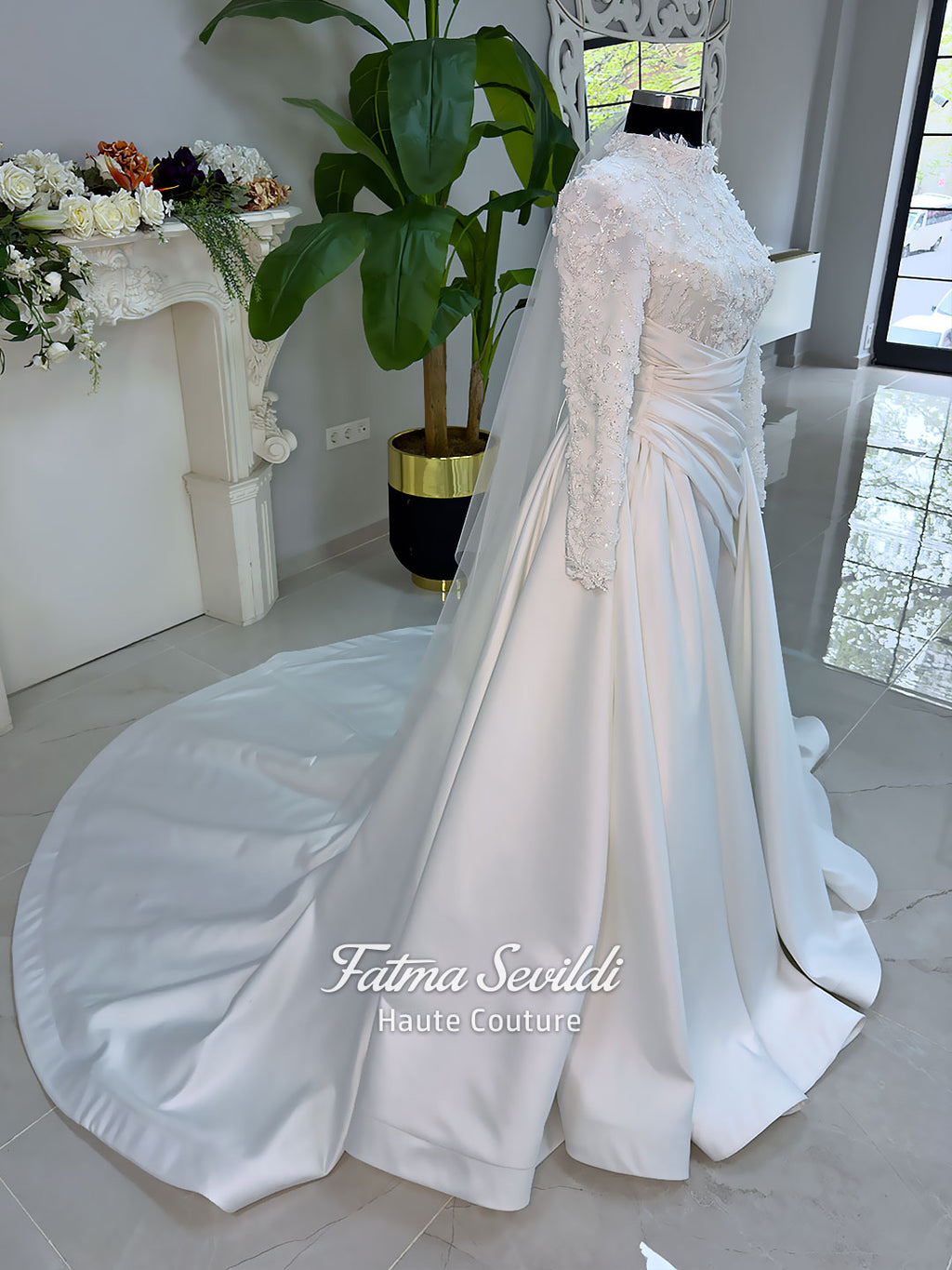 Luxury modest hijab wedding dress with long sleeves, 3D floral beaded lace bodice, draped satin A-line skirt and lace-edged veil included, shown on mannequin. Custom made Islamic bridal gown with elegant full coverage.