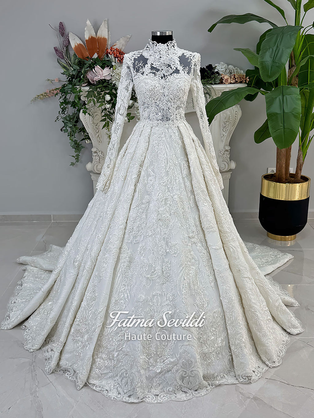 Ivory luxury hijab wedding dress featuring long lace sleeves, a high neckline, full beaded floral lace princess skirt, dramatic train and coordinating premium lace veil.