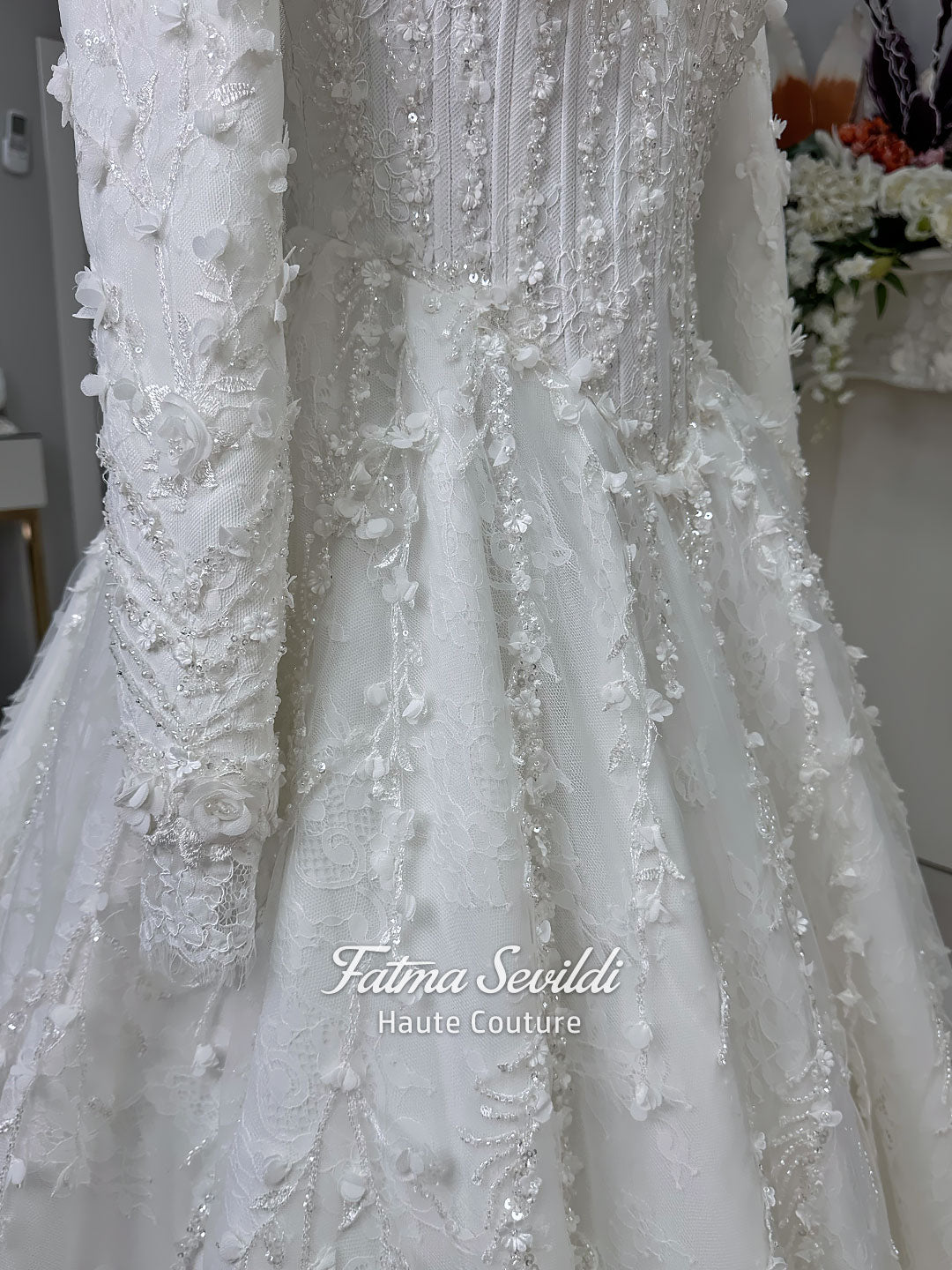 White hijab wedding dress with long sleeves, high lace neckline, floral embroidery and a full modest bridal skirt, shown with a premium lace veil. Luxury Muslim wedding gown with detailed lace and elegant full coverage.