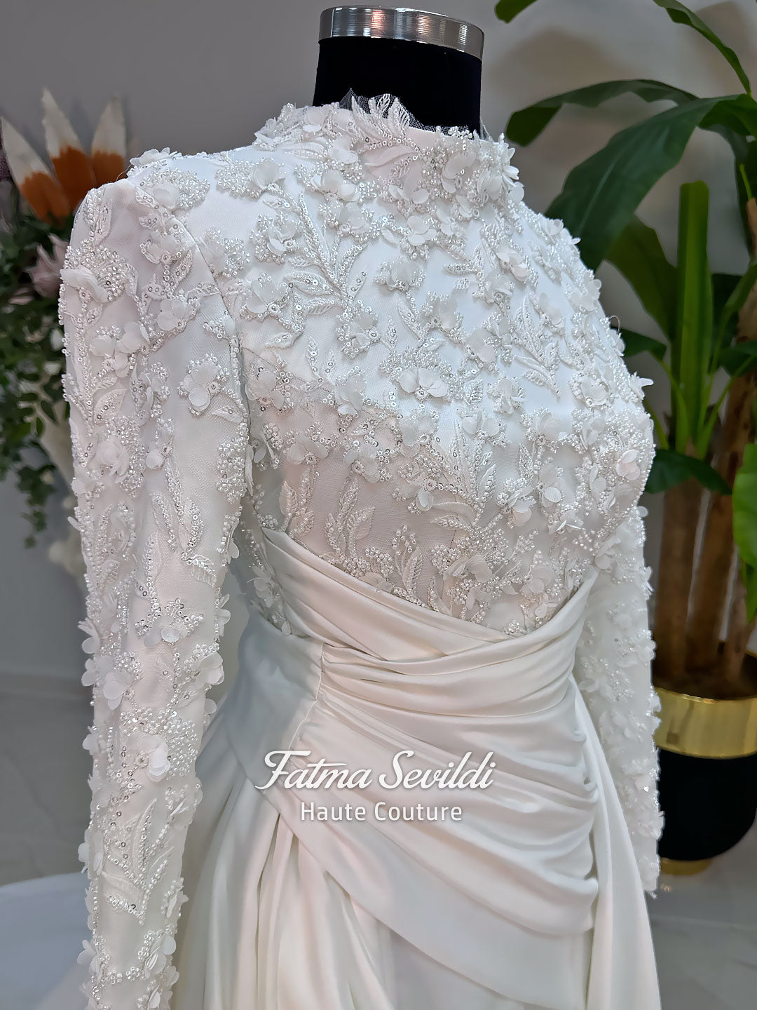 Luxury modest hijab wedding dress with long sleeves, 3D floral beaded lace bodice, draped satin A-line skirt and lace-edged veil included, shown on mannequin. Custom made Islamic bridal gown with elegant full coverage.