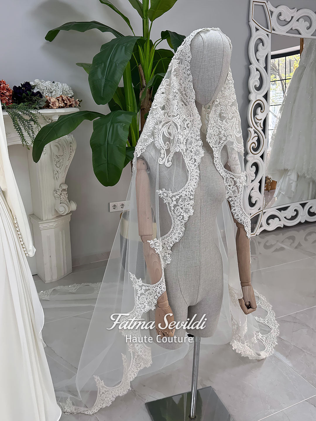 Luxury ivory hijab wedding dress with a high neckline, long sleeves, draped satin skirt and included premium lace veil displayed in a bridal atelier.