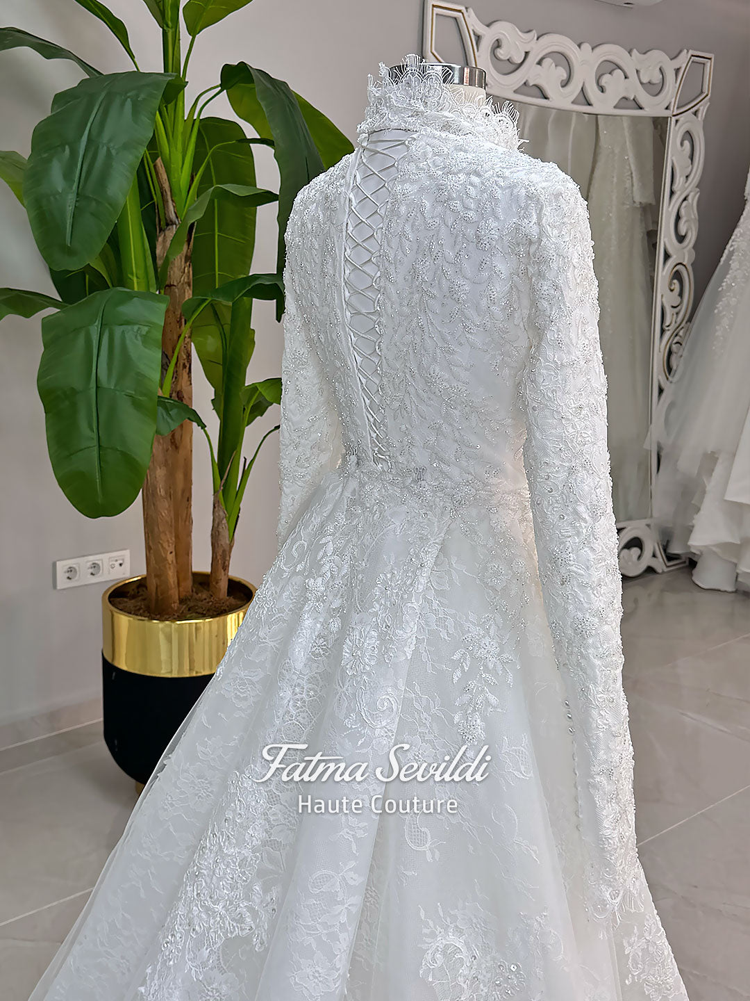Luxury hijab wedding dress with long sleeves, high mock neck, floral lace embroidery, detachable mermaid skirt, dramatic train and premium lace veil for a modest Muslim bride.