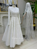 Luxury modest hijab wedding dress with long sleeves and A-line silhouette, fully beaded embroidery, shown with embellished lace cathedral veil.