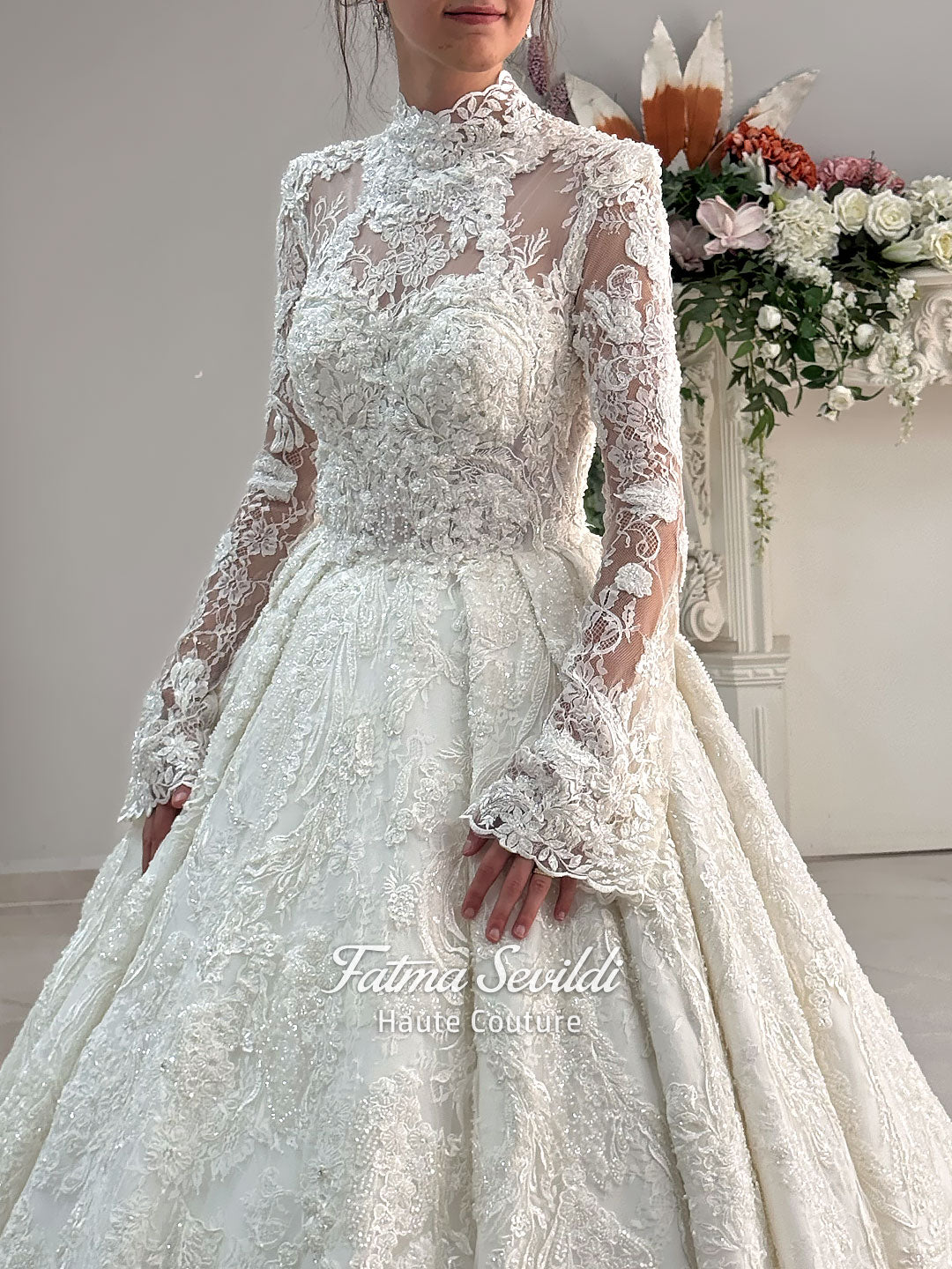 Ivory luxury hijab wedding dress featuring long lace sleeves, a high neckline, full beaded floral lace princess skirt, dramatic train and coordinating premium lace veil.