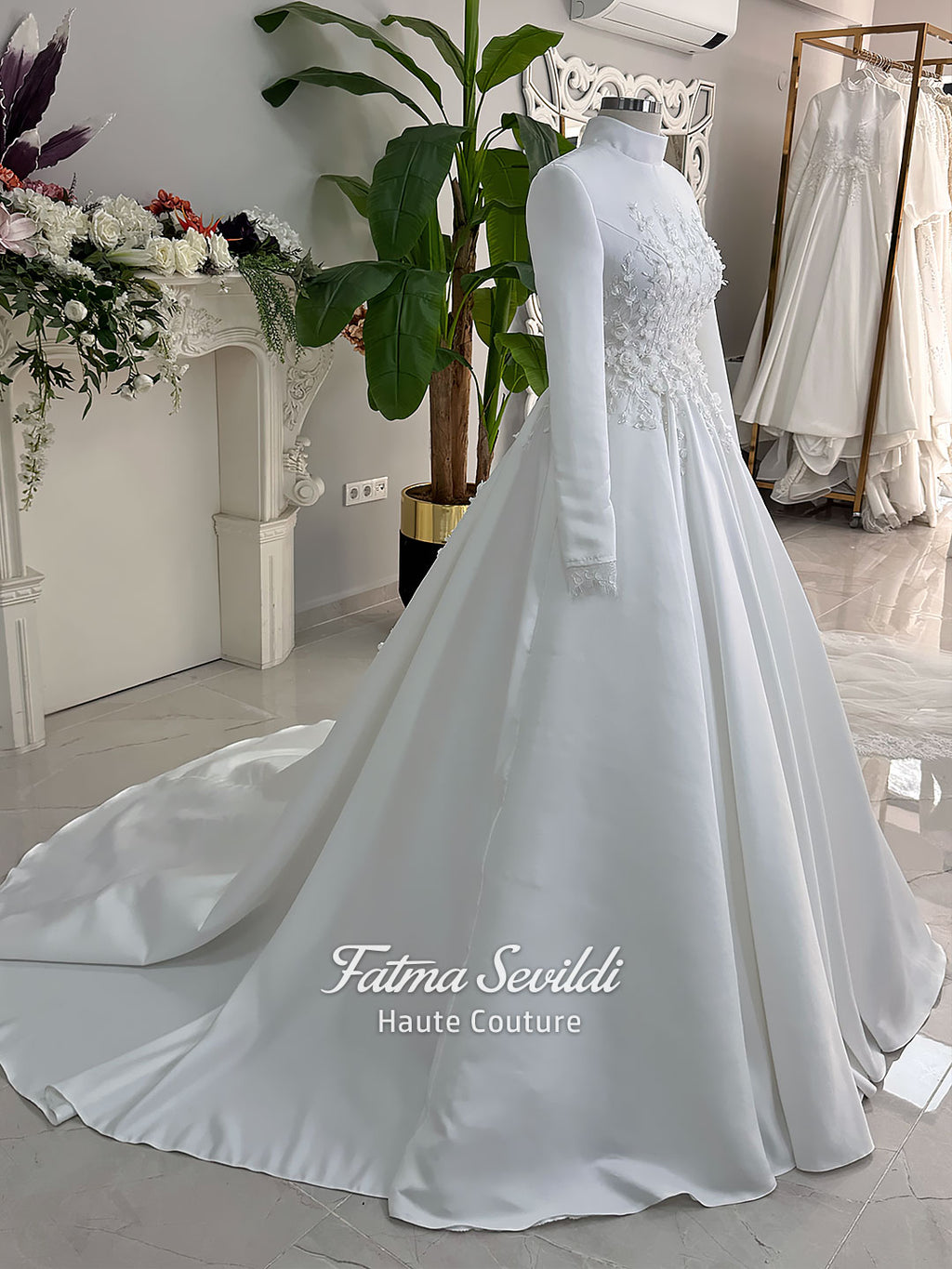 White A-line satin hijab wedding dress with long sleeves, high neckline, floral appliqué embroidery and an included premium lace mantilla veil for a modest Muslim bridal look.