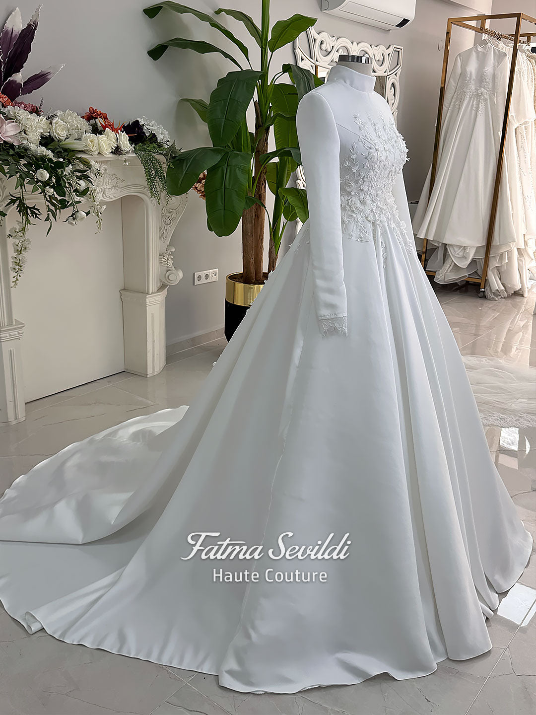 White A-line satin hijab wedding dress with long sleeves, high neckline, floral appliqué embroidery and an included premium lace mantilla veil for a modest Muslim bridal look.