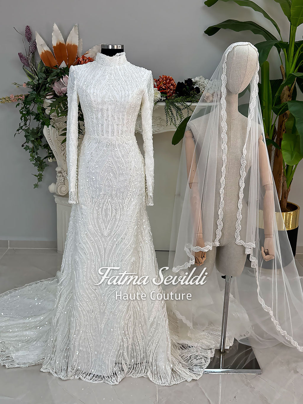 Luxury hijab wedding dress with long sleeves, high neck, beaded lace mermaid silhouette and detachable overskirt, veiled bridal set. Handmade couture modest bridal gown with lace-up corset back and sparkling embroidery.
