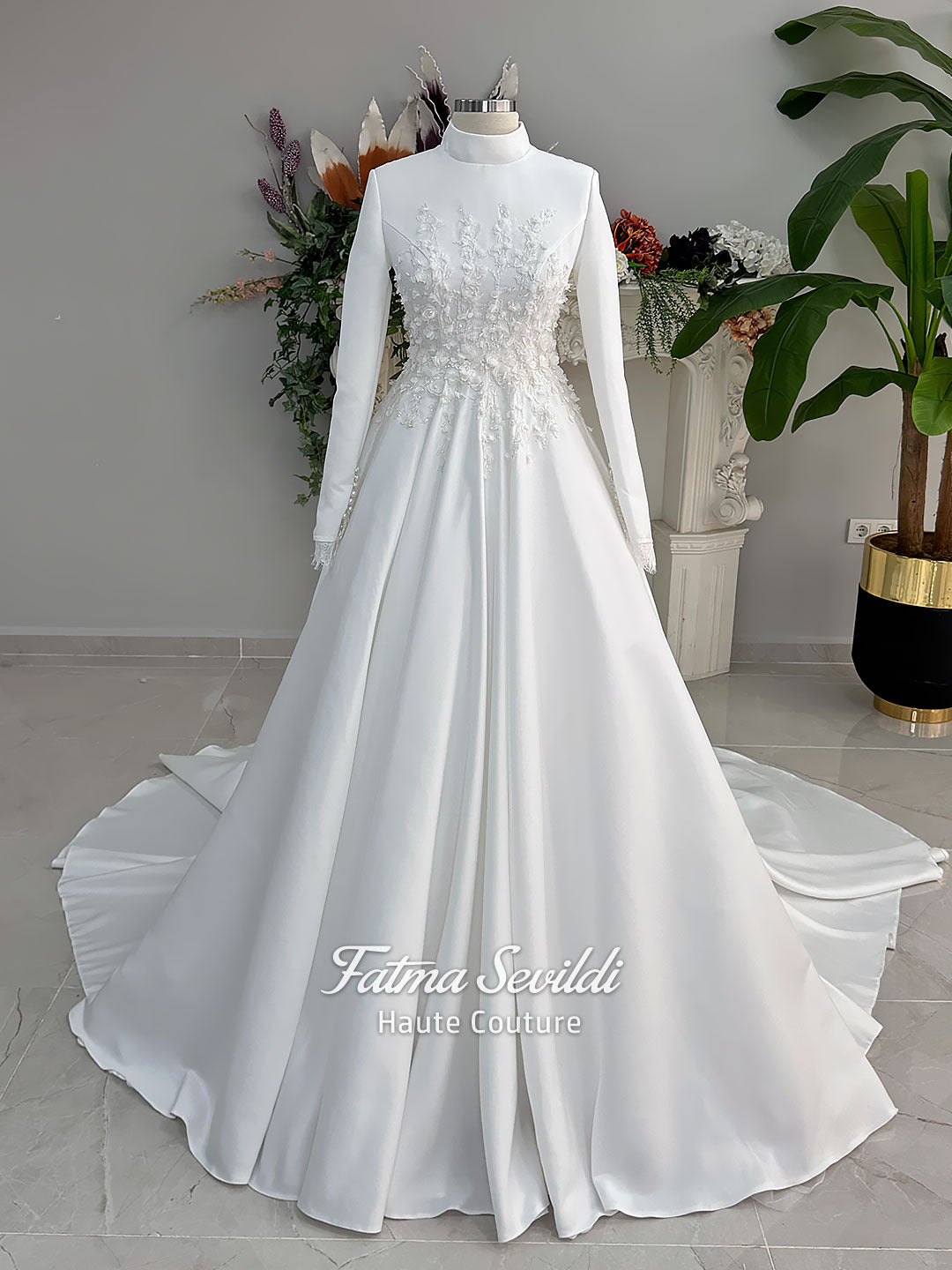 White A-line satin hijab wedding dress with long sleeves, high neckline, floral appliqué embroidery and an included premium lace mantilla veil for a modest Muslim bridal look.