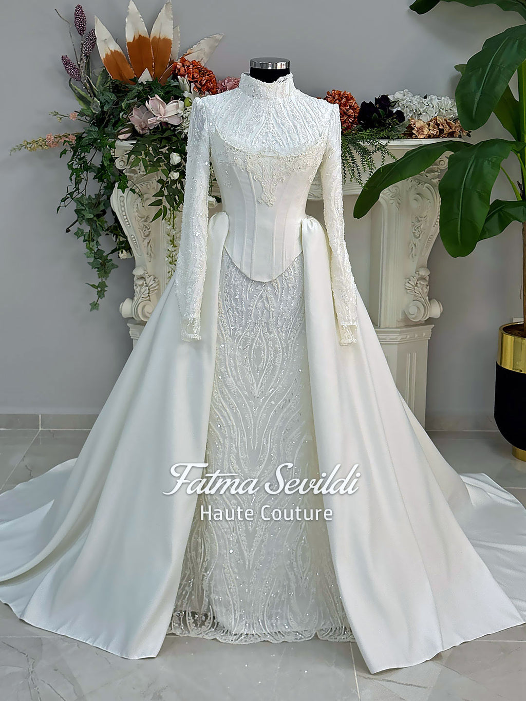 Luxury hijab wedding dress with long sleeves, high neck, beaded lace mermaid silhouette and detachable overskirt, veiled bridal set. Handmade couture modest bridal gown with lace-up corset back and sparkling embroidery.