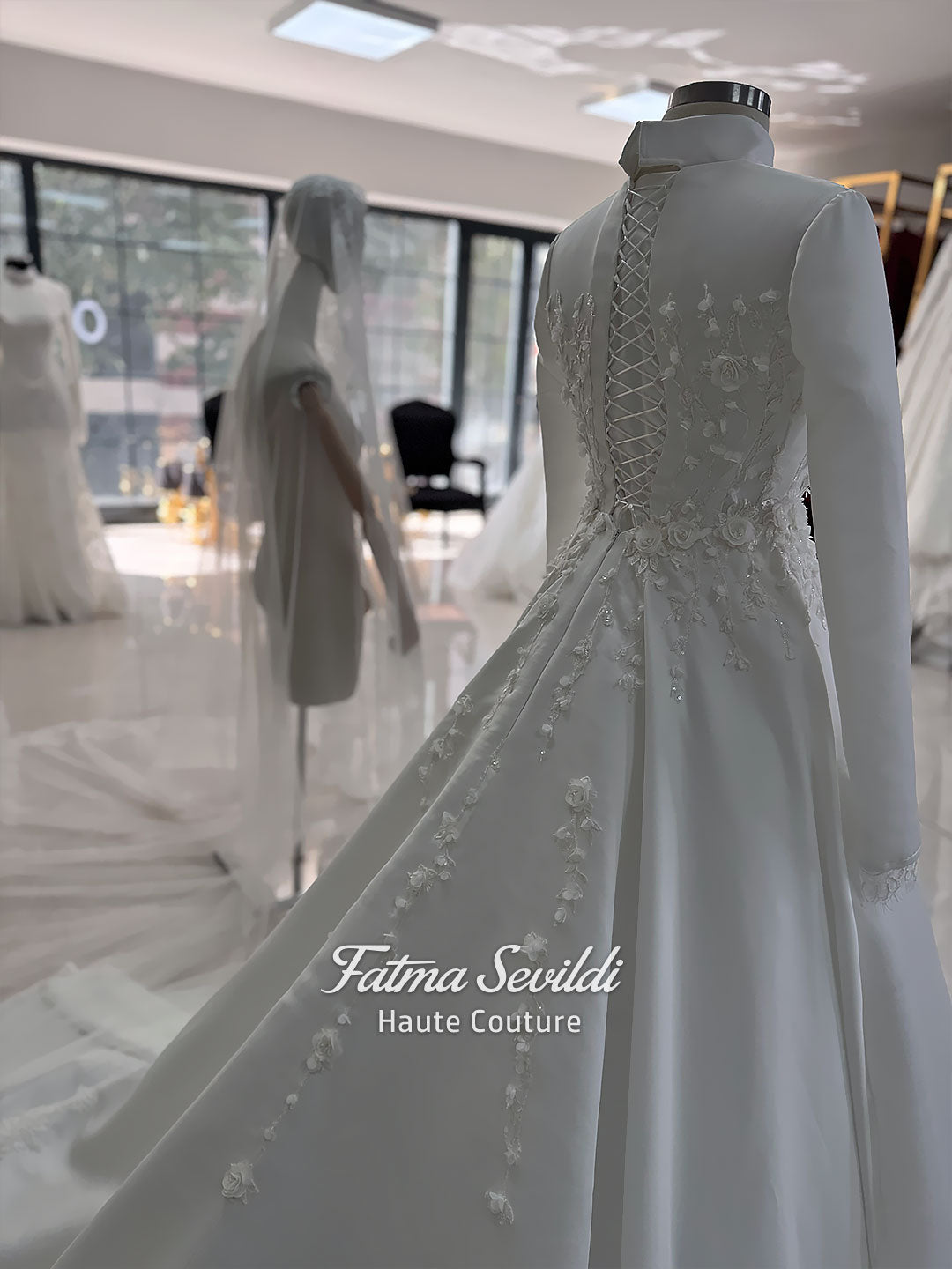 White A-line satin hijab wedding dress with long sleeves, high neckline, floral appliqué embroidery and an included premium lace mantilla veil for a modest Muslim bridal look.