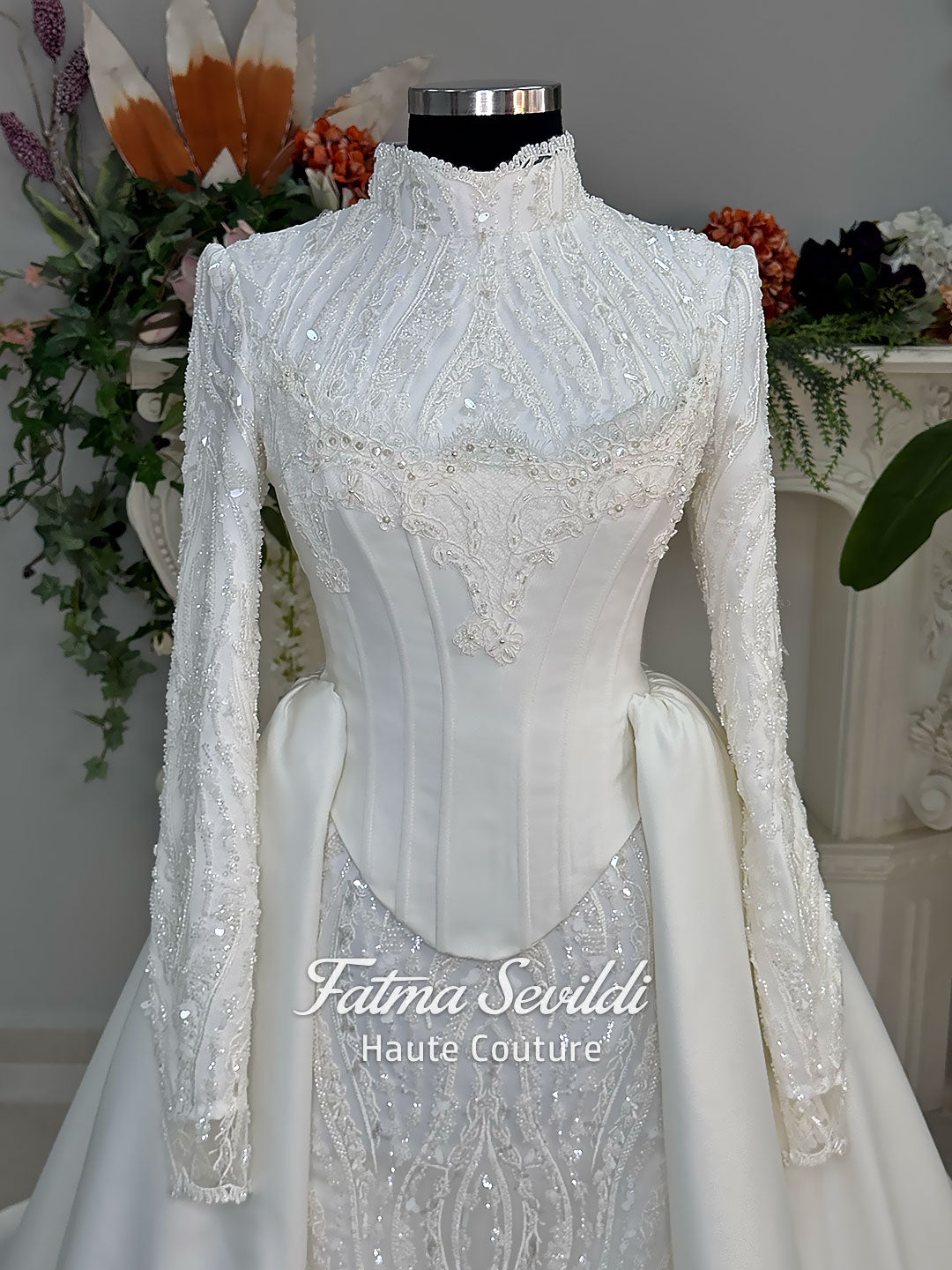 Luxury hijab wedding dress with long sleeves, high neck, beaded lace mermaid silhouette and detachable overskirt, veiled bridal set. Handmade couture modest bridal gown with lace-up corset back and sparkling embroidery.