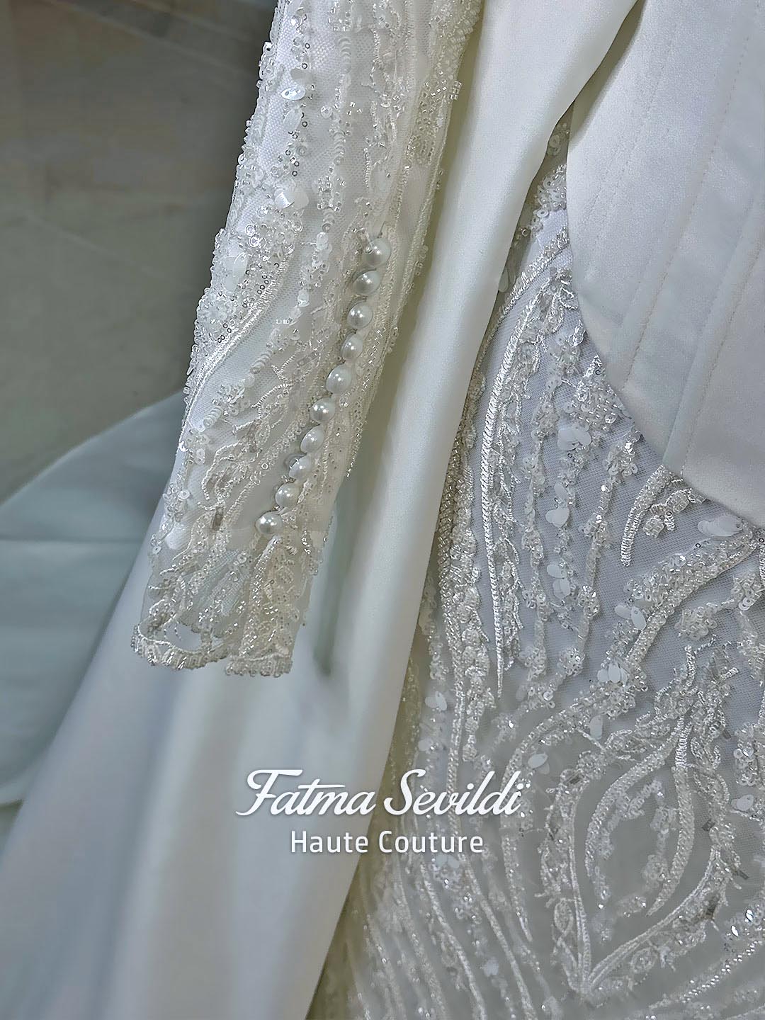 Luxury hijab wedding dress with long sleeves, high neck, beaded lace mermaid silhouette and detachable overskirt, veiled bridal set. Handmade couture modest bridal gown with lace-up corset back and sparkling embroidery.