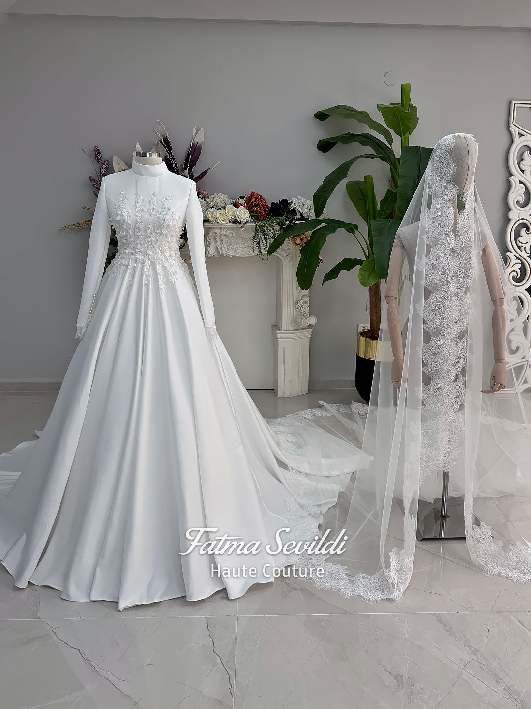 White A-line satin hijab wedding dress with long sleeves, high neckline, floral appliqué embroidery and an included premium lace mantilla veil for a modest Muslim bridal look.