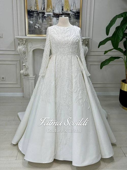 White beaded lace Muslim wedding dress with long sleeves and flowing skirt