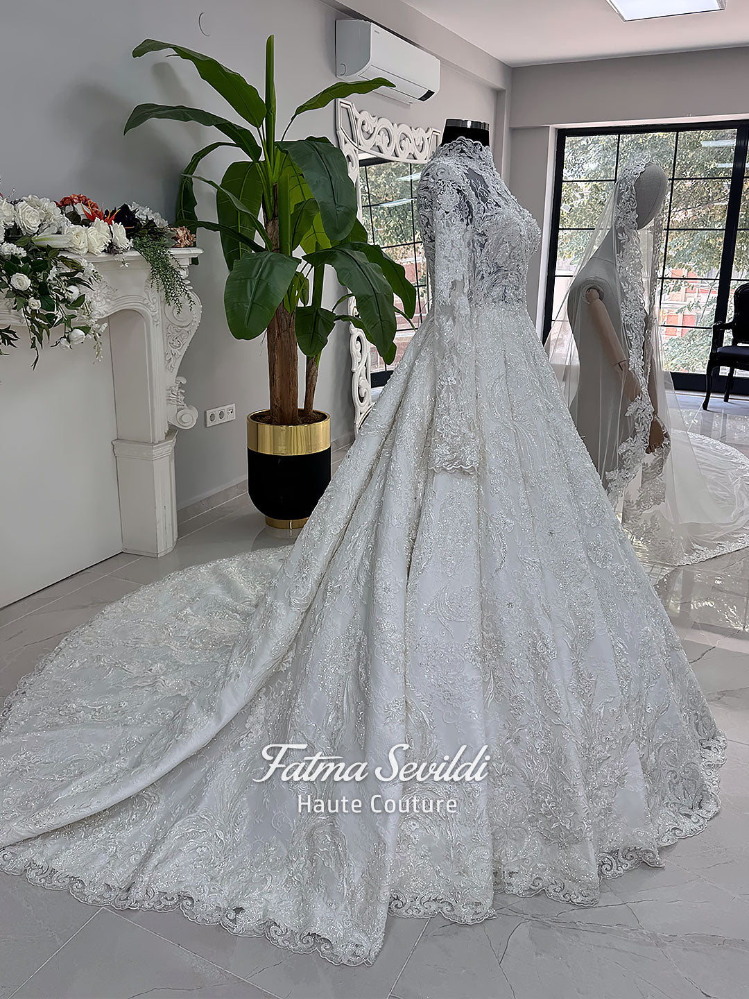Ivory luxury hijab wedding dress featuring long lace sleeves, a high neckline, full beaded floral lace princess skirt, dramatic train and coordinating premium lace veil.