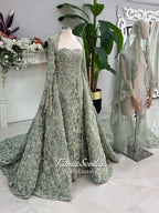 Sage green evening dress with beaded floral lace, a sweetheart neckline and long sleeves with flared lace cuffs, displayed on a mannequin.