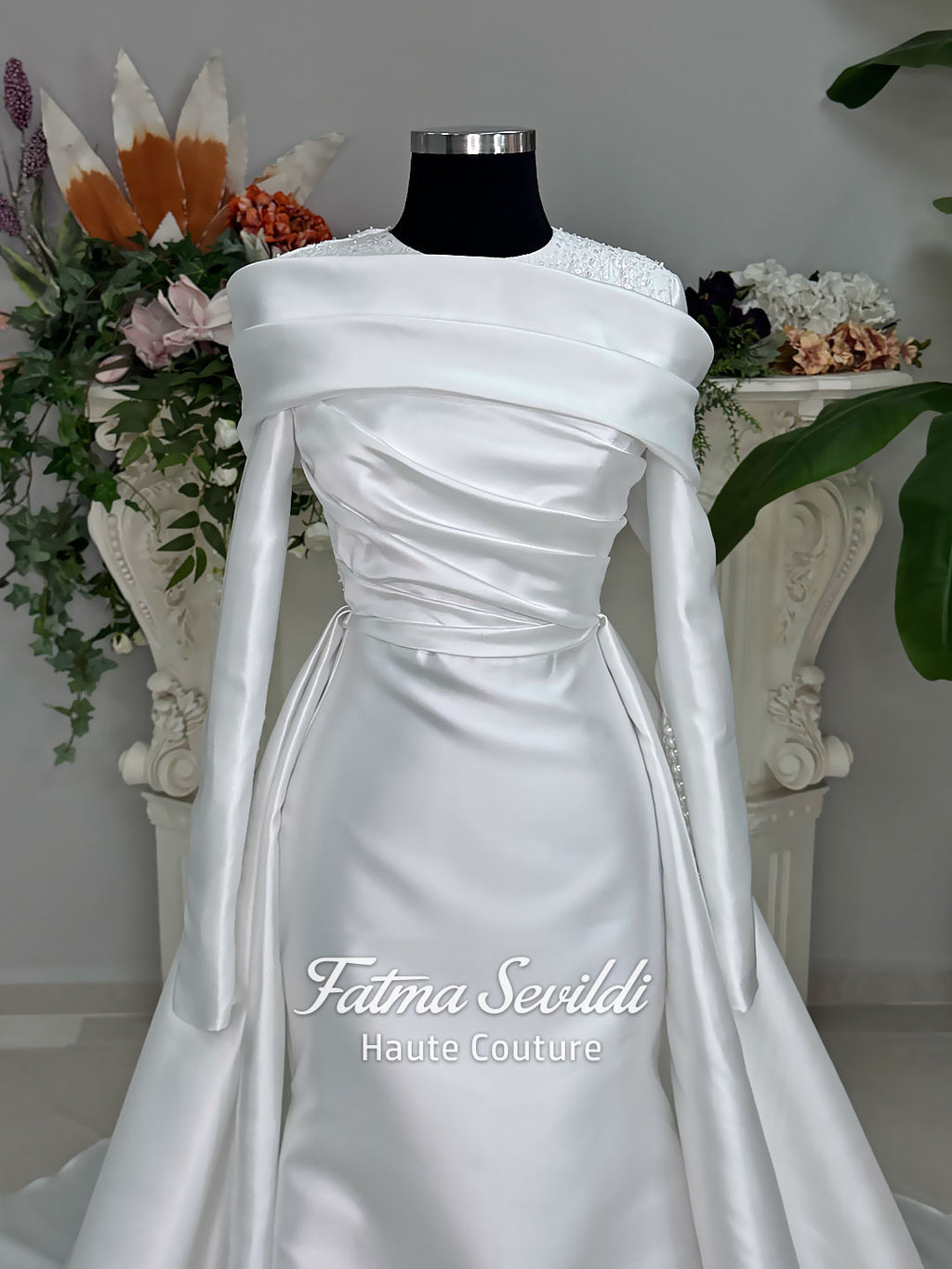 Luxury satin hijab wedding dress with off-shoulder long sleeves and an A-line silhouette, shown with premium lace veil and dramatic train. Custom couture modest bridal gown design with elegant draping and pearl details.