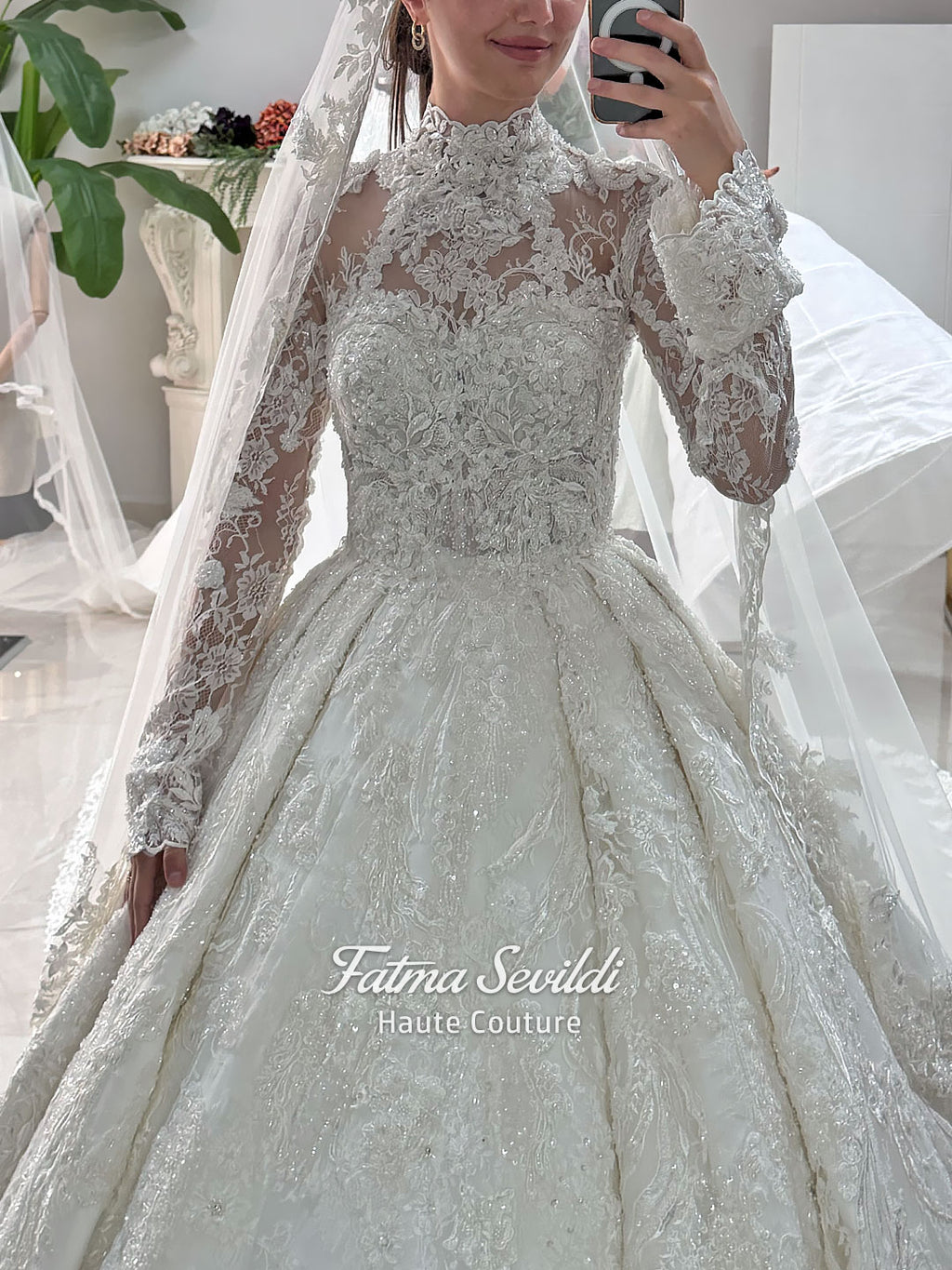 Ivory luxury hijab wedding dress featuring long lace sleeves, a high neckline, full beaded floral lace princess skirt, dramatic train and coordinating premium lace veil.