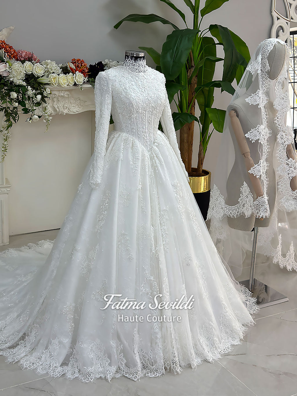Luxury modest hijab wedding dress ball gown with long sleeves, high neck corset bodice, lace appliqué and included lace veil, photographed in a bridal atelier.