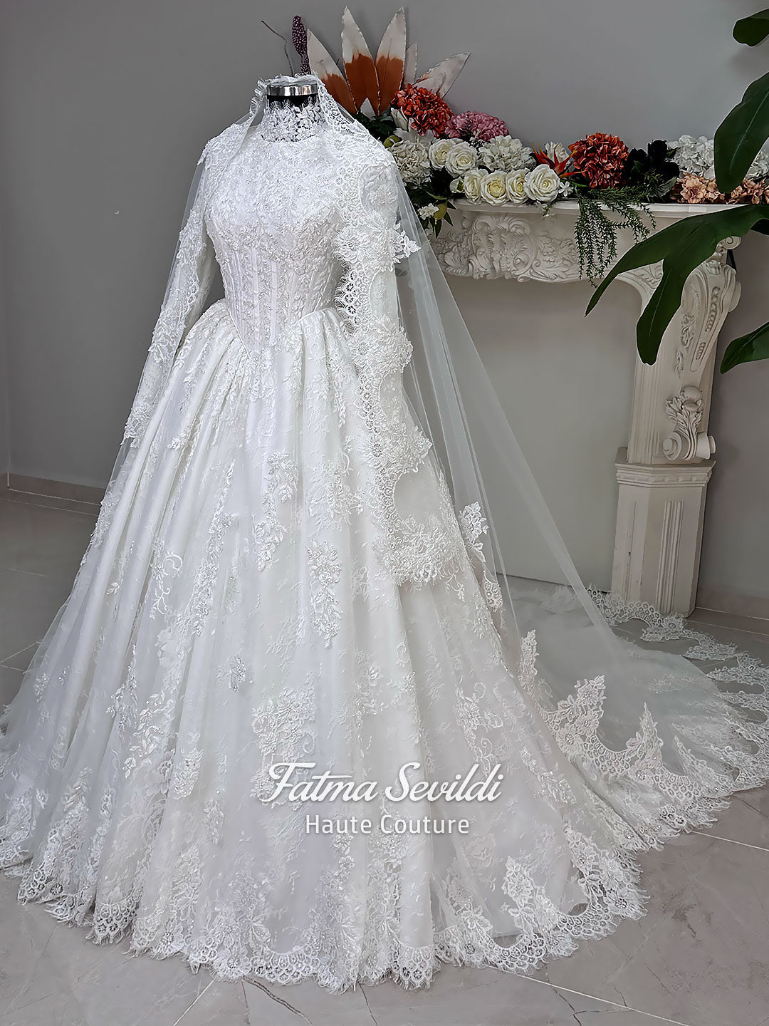 Luxury modest hijab wedding dress ball gown with long sleeves, high neck corset bodice, lace appliqué and included lace veil, photographed in a bridal atelier.