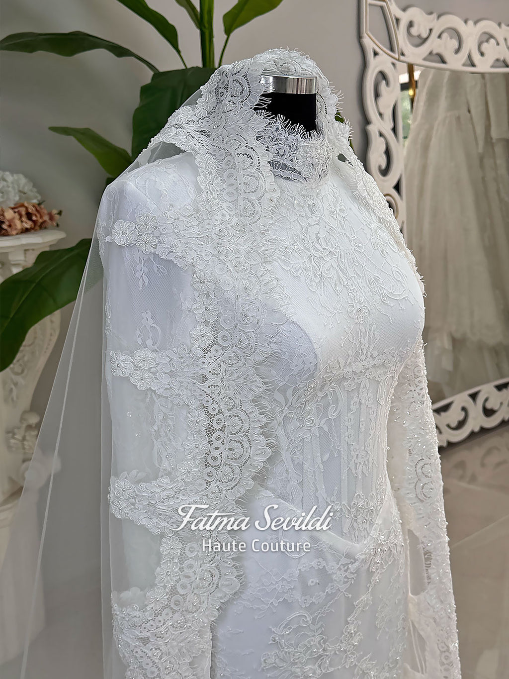 Luxury hijab wedding dress with mermaid silhouette and basque corset, featuring long sleeves, high neck lace, and a premium lace veil. Photographed on a mannequin in a bridal atelier setting.