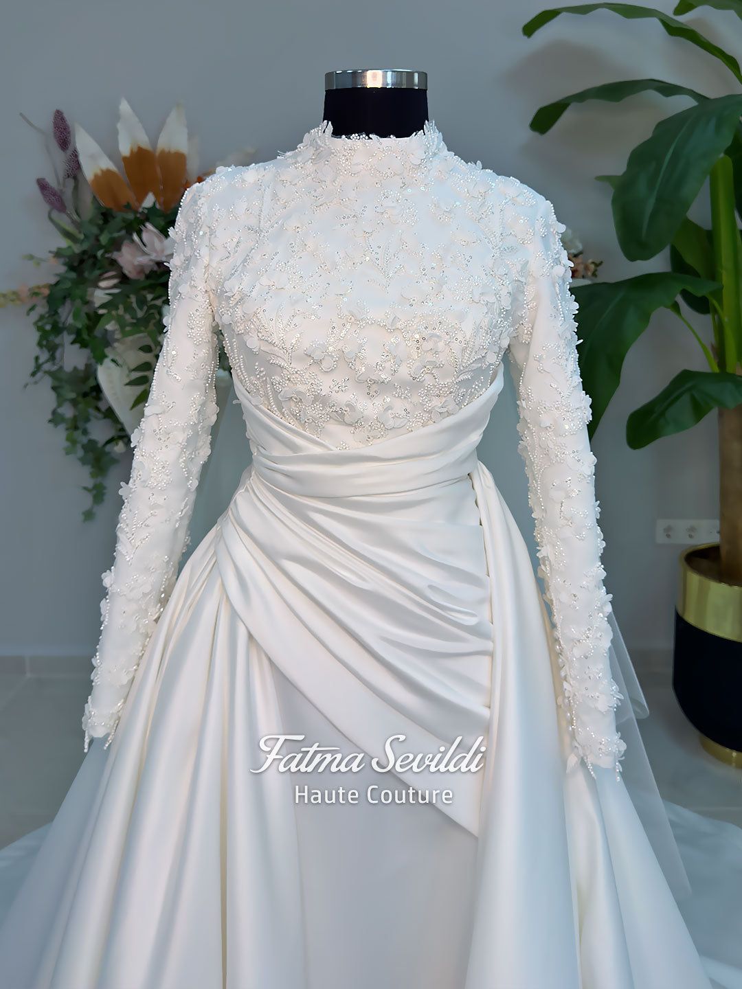 Luxury modest hijab wedding dress with long sleeves, 3D floral beaded lace bodice, draped satin A-line skirt and lace-edged veil included, shown on mannequin. Custom made Islamic bridal gown with elegant full coverage.
