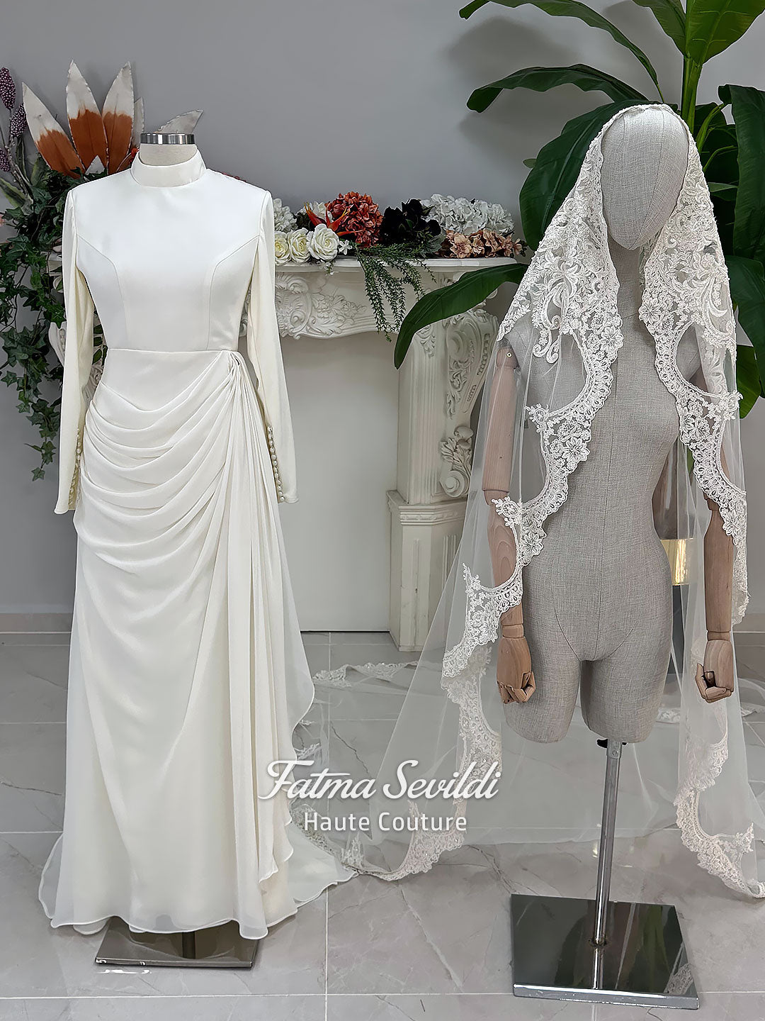 Luxury ivory hijab wedding dress with a high neckline, long sleeves, draped satin skirt and included premium lace veil displayed in a bridal atelier.