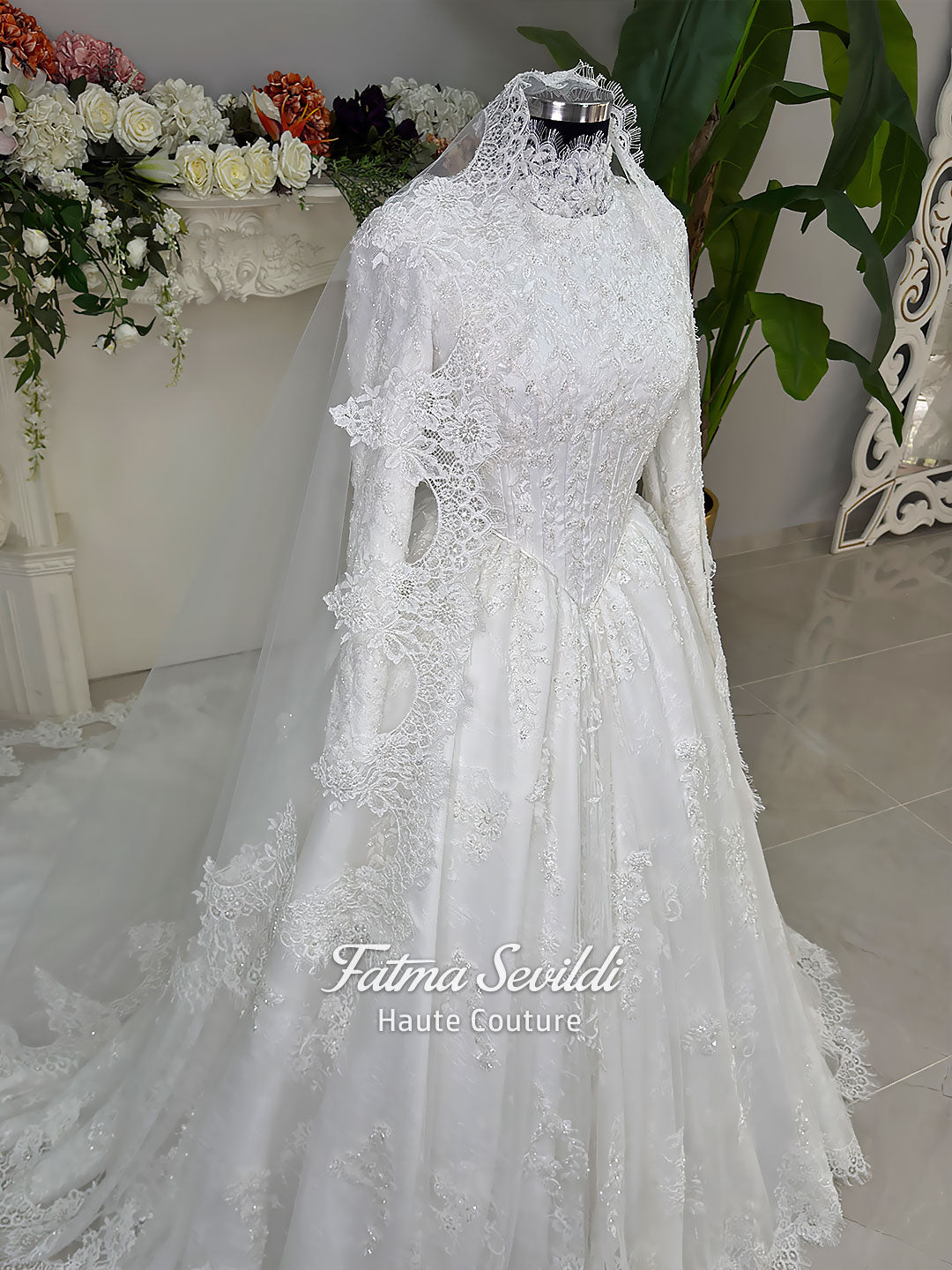 Luxury modest hijab wedding dress ball gown with long sleeves, high neck corset bodice, lace appliqué and included lace veil, photographed in a bridal atelier.