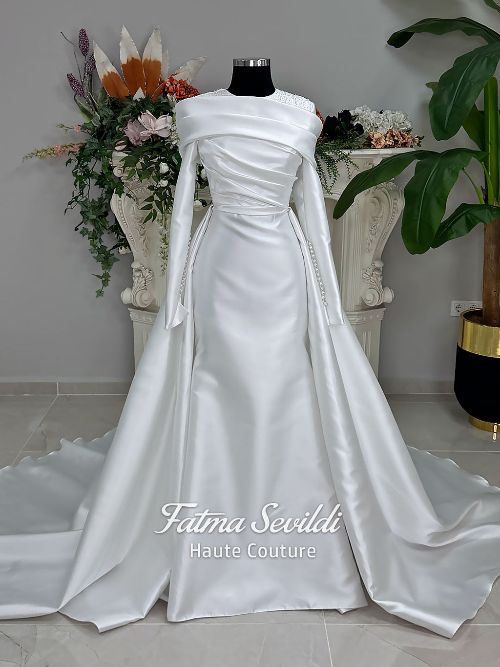Luxury satin hijab wedding dress with off-shoulder long sleeves and an A-line silhouette, shown with premium lace veil and dramatic train. Custom couture modest bridal gown design with elegant draping and pearl details.