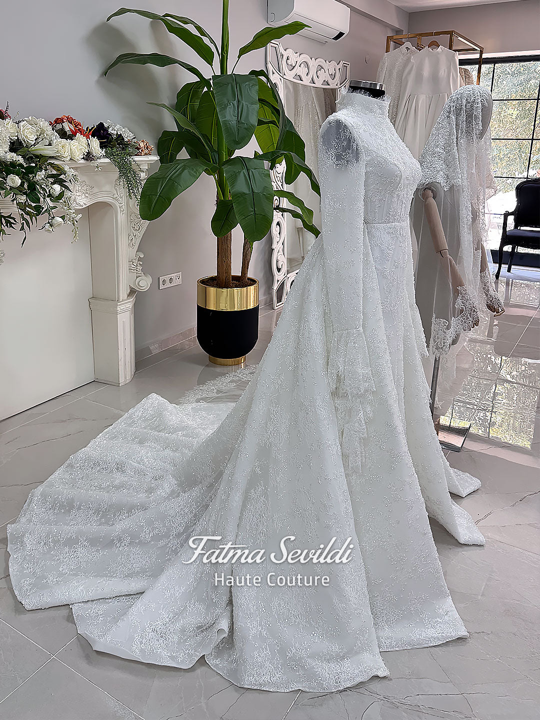 Luxury hijab wedding dress with long flounce sleeves, a high mock neckline, beaded floral lace, corset fit, mermaid silhouette, detachable overskirt, and included lace veil. Modest Muslim bridal gown shown from front, back, and detail views.