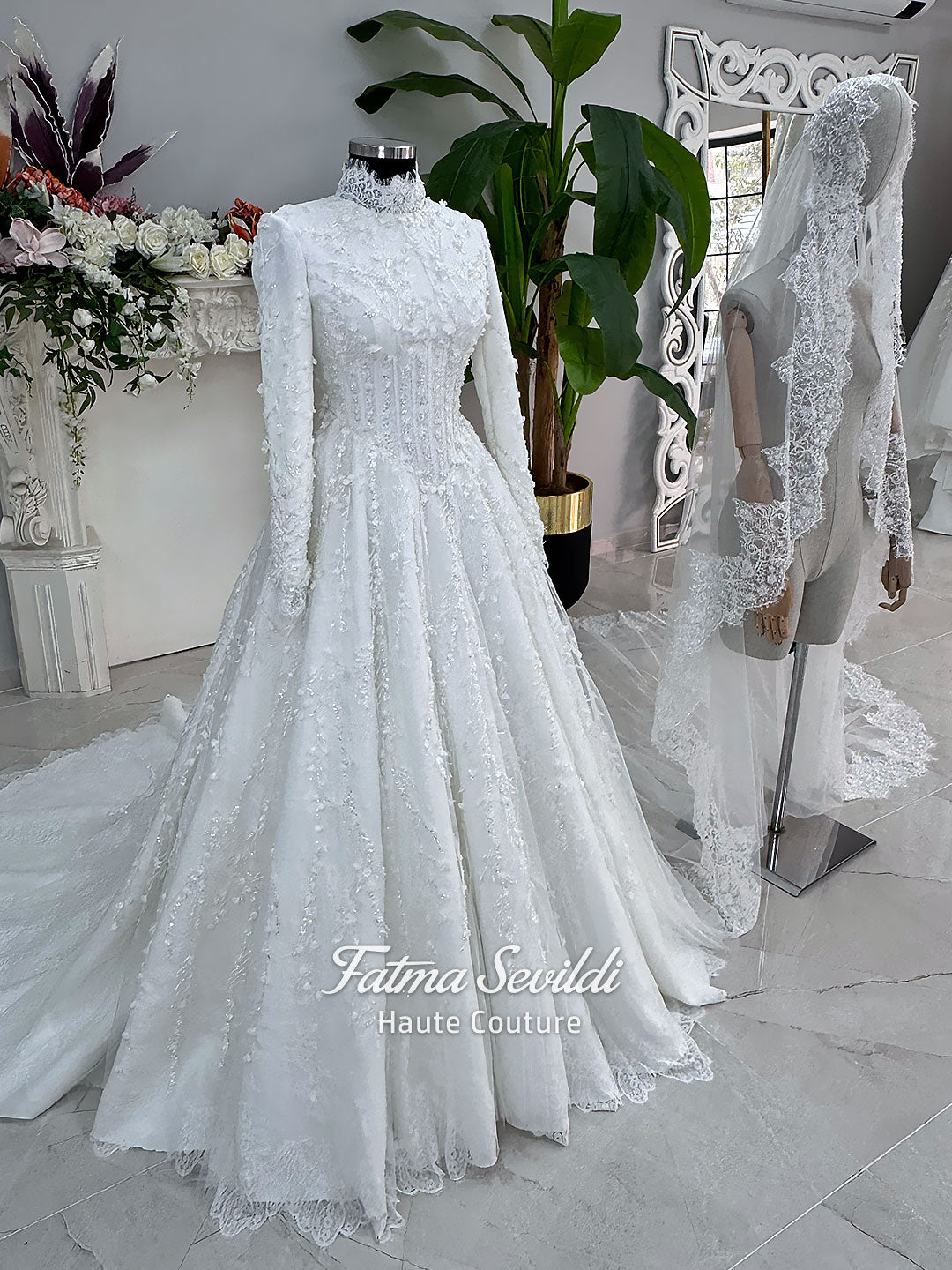 White hijab wedding dress with long sleeves, high lace neckline, floral embroidery and a full modest bridal skirt, shown with a premium lace veil. Luxury Muslim wedding gown with detailed lace and elegant full coverage.