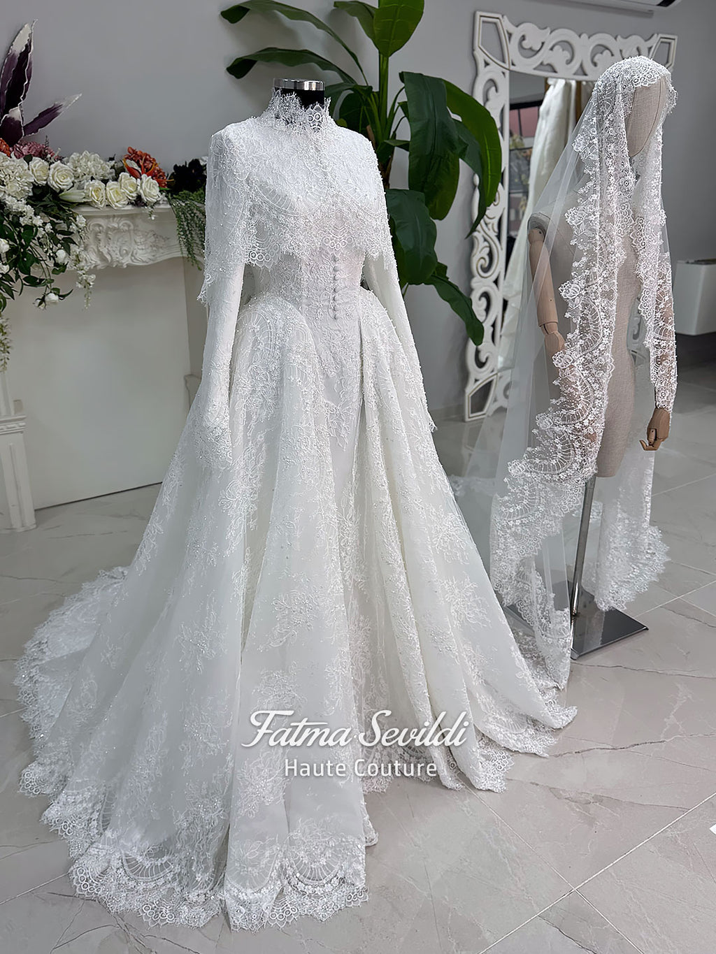 Off-white hijab wedding dress by Fatma Sevildi with beaded floral lace, a basque waist, long sleeves and a high neckline.