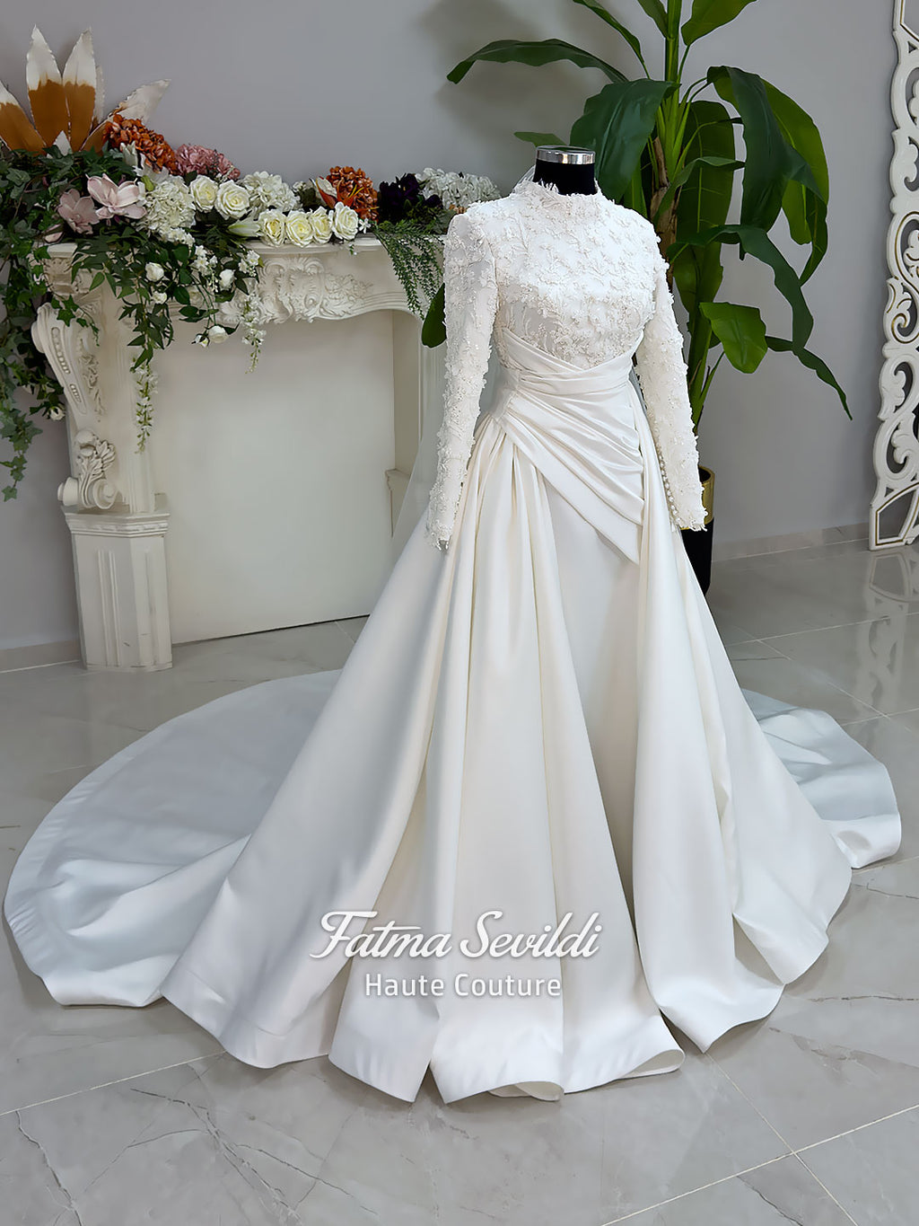 Luxury modest hijab wedding dress with long sleeves, 3D floral beaded lace bodice, draped satin A-line skirt and lace-edged veil included, shown on mannequin. Custom made Islamic bridal gown with elegant full coverage.