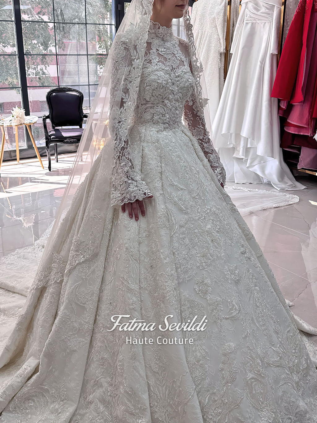 Ivory luxury hijab wedding dress featuring long lace sleeves, a high neckline, full beaded floral lace princess skirt, dramatic train and coordinating premium lace veil.