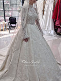 Ivory luxury hijab wedding dress featuring long lace sleeves, a high neckline, full beaded floral lace princess skirt, dramatic train and coordinating premium lace veil.