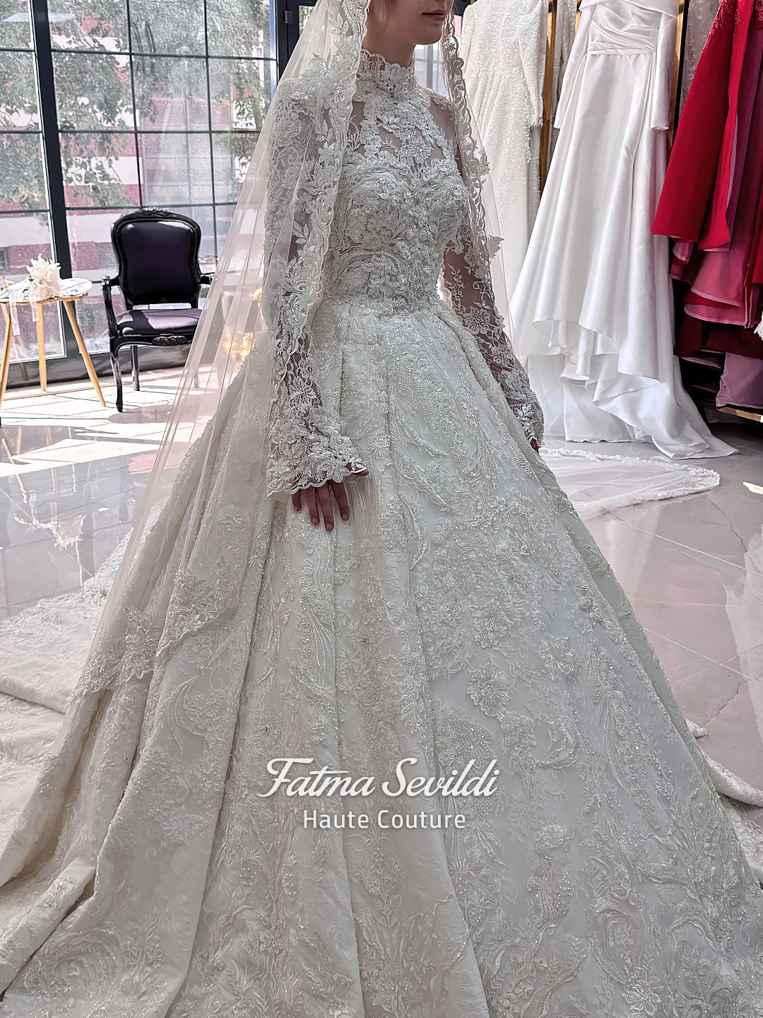 Ivory luxury hijab wedding dress featuring long lace sleeves, a high neckline, full beaded floral lace princess skirt, dramatic train and coordinating premium lace veil.