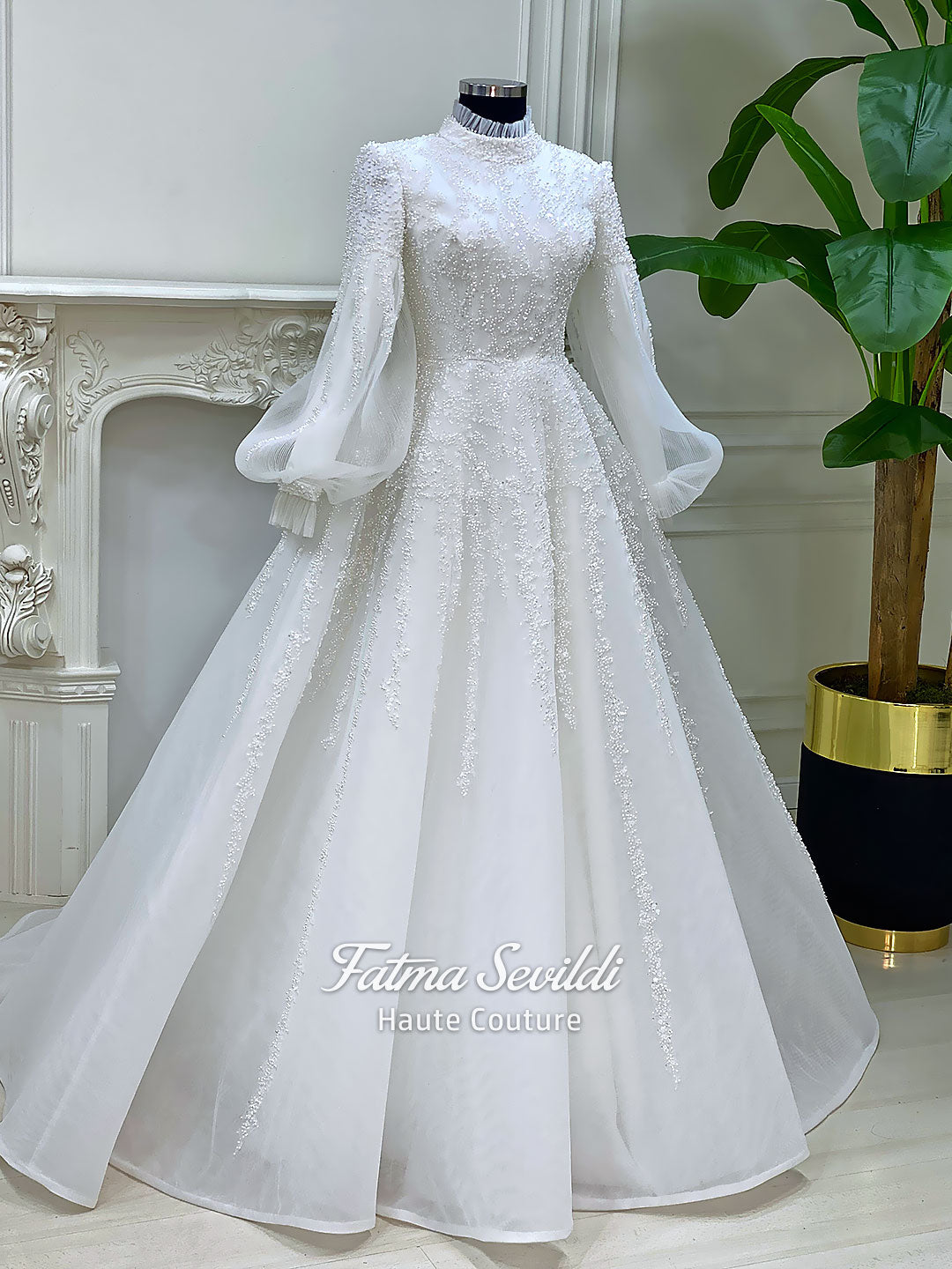Luxury hijab wedding dress in an A-line tulle ball gown silhouette with long balloon sleeves, high neck, sparkling beadwork, and a lace-edged veil.