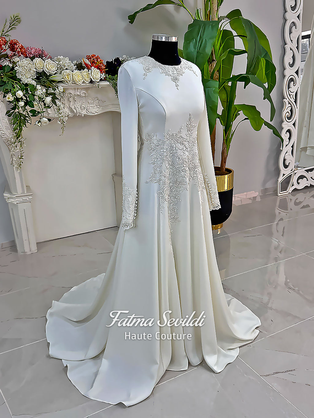 Ivory long sleeve hijab wedding dress with detachable lace-edged cape, floral beaded embroidery, high neckline and floor-length A-line modest bridal silhouette. Designed for Muslim brides seeking an elegant luxury wedding gown with full coverage.