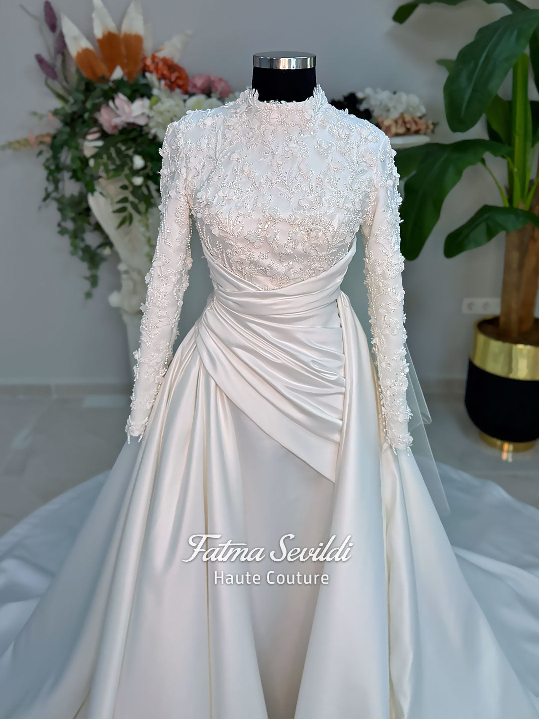 Luxury modest hijab wedding dress with long sleeves, 3D floral beaded lace bodice, draped satin A-line skirt and lace-edged veil included, shown on mannequin. Custom made Islamic bridal gown with elegant full coverage.