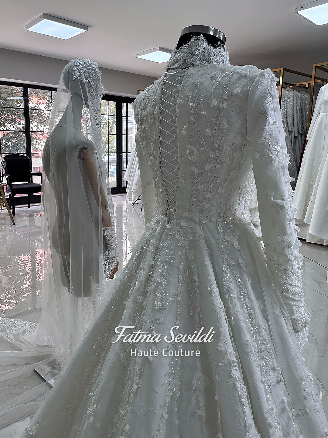 White hijab wedding dress with long sleeves, high lace neckline, floral embroidery and a full modest bridal skirt, shown with a premium lace veil. Luxury Muslim wedding gown with detailed lace and elegant full coverage.