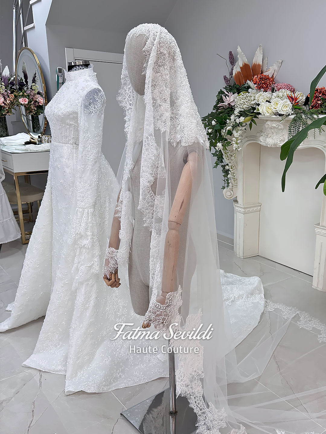 Luxury hijab wedding dress with long flounce sleeves, a high mock neckline, beaded floral lace, corset fit, mermaid silhouette, detachable overskirt, and included lace veil. Modest Muslim bridal gown shown from front, back, and detail views.