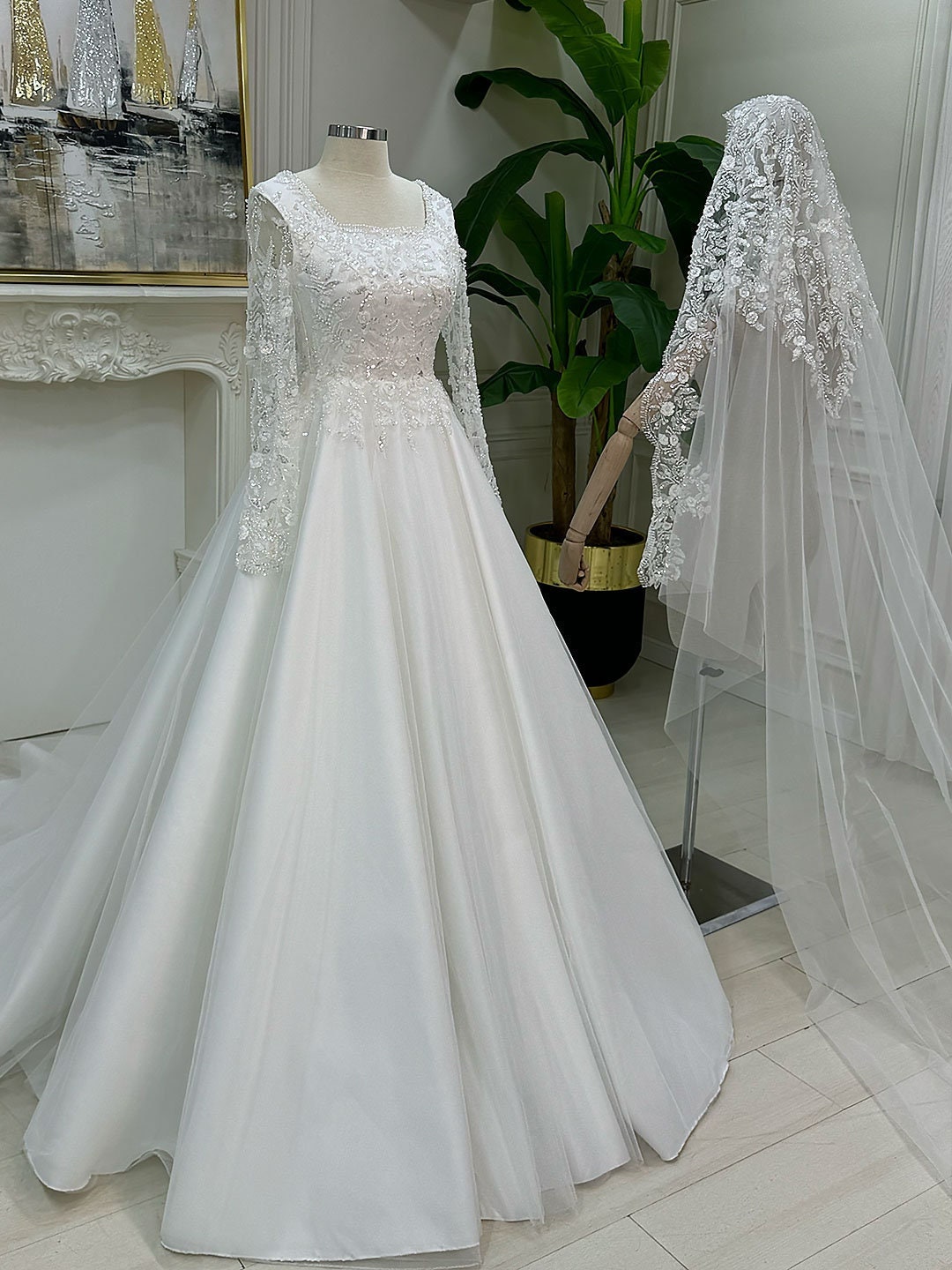 Elegant A-Line lace wedding dress with square neck, long sleeves, beaded bodice, and sheer veil