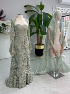Sage green evening dress with beaded floral lace, a sweetheart neckline and long sleeves with flared lace cuffs, displayed on a mannequin.