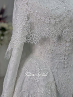 Off-white hijab wedding dress by Fatma Sevildi with beaded floral lace, a basque waist, long sleeves and a high neckline.