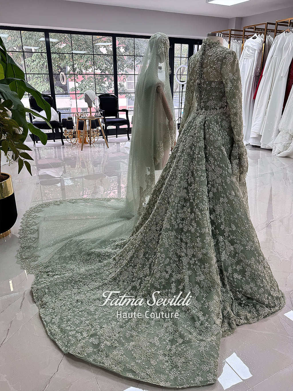Sage green evening dress with beaded floral lace, a sweetheart neckline and long sleeves with flared lace cuffs, displayed on a mannequin.